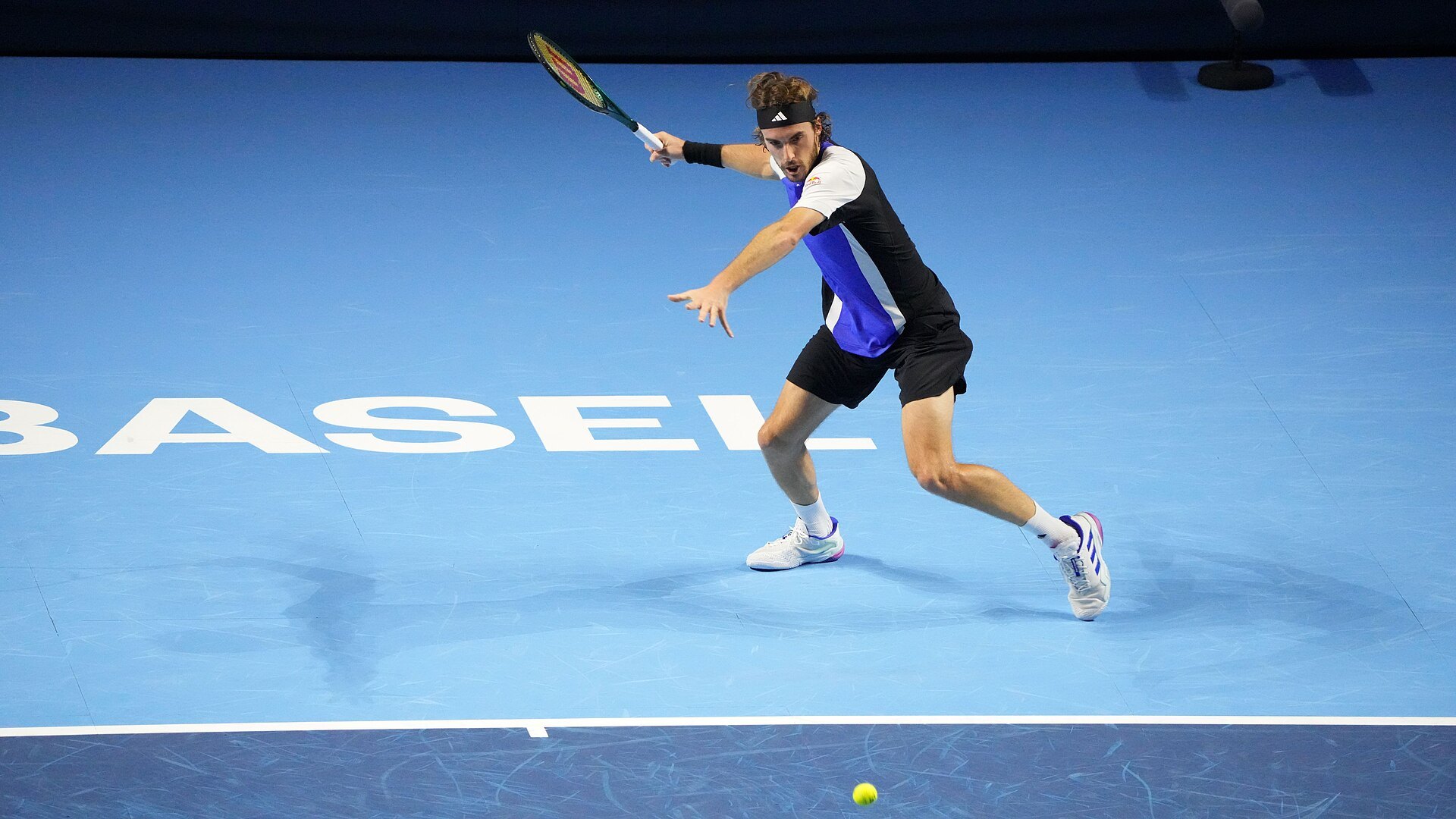 Тенисист в движение на синия корт с надпис BASEL по време на Swiss Indoors 2024 в зала „Санкт Якобсхале“