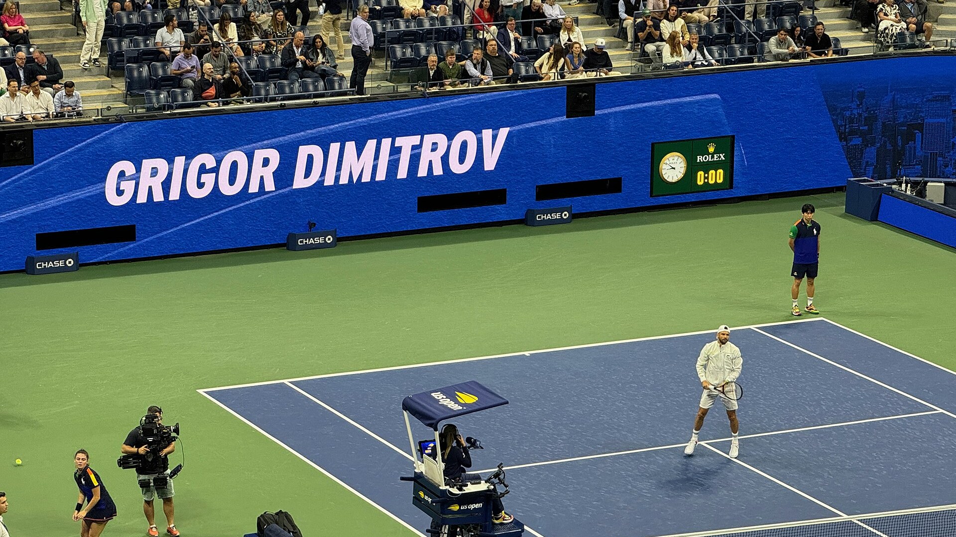 Григор Димитров и Франсис Тиафо на корта на US Open през 2024 г., зад тях надпис с името на българина