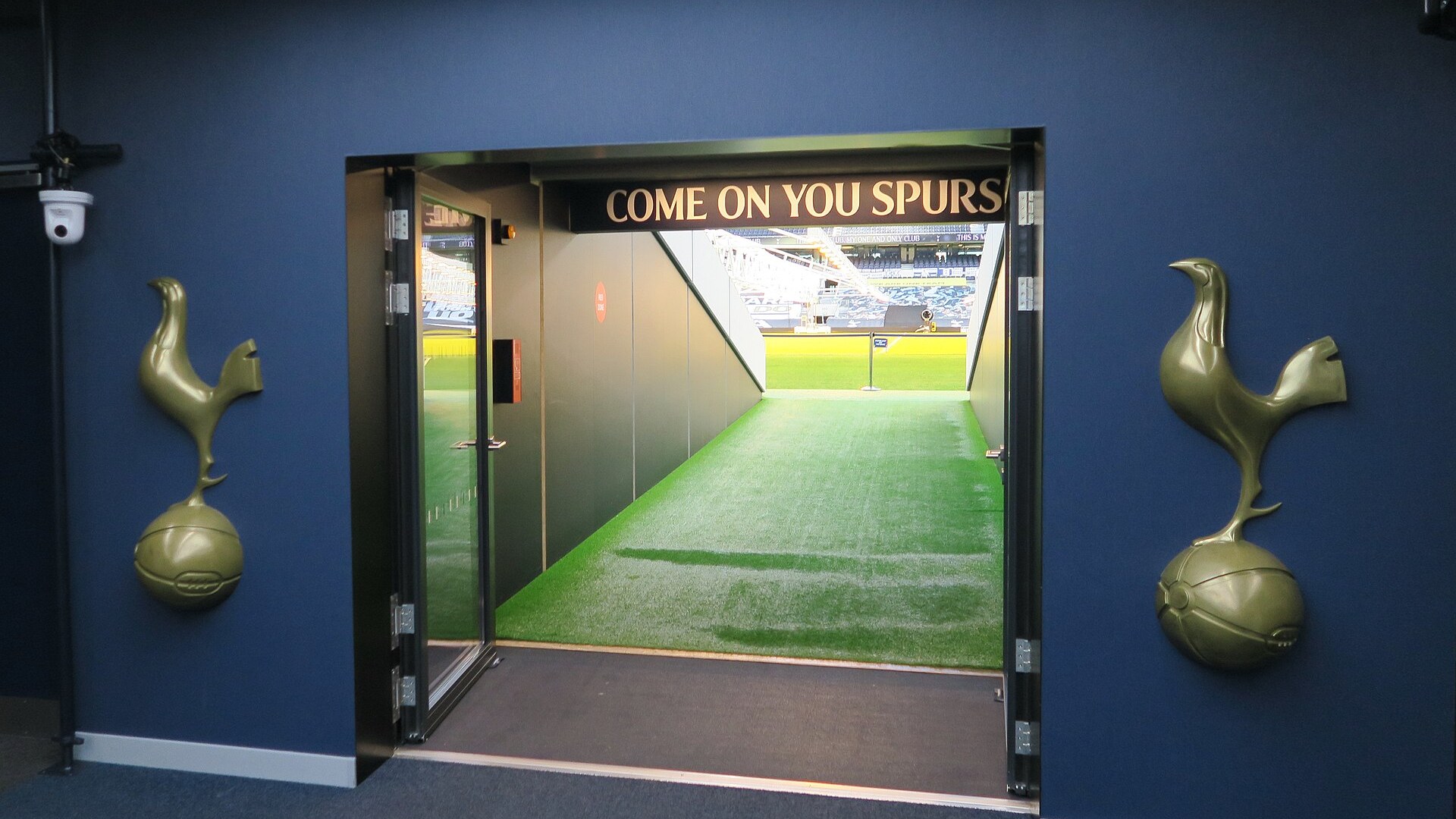 Тунелът за играчите на стадион „Тотнъм Хотспър“ с надпис Come on you Spurs и изглед към терена