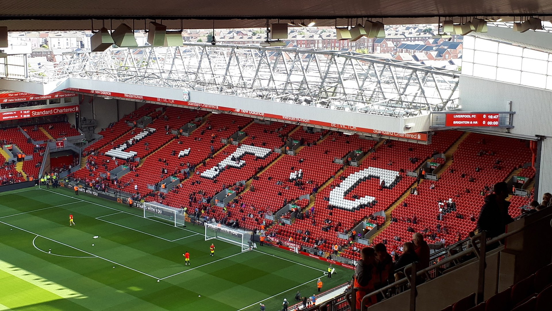 Трибуната „Коп“ на стадион „Анфийлд“ в Ливърпул с надпис LFC на седалките